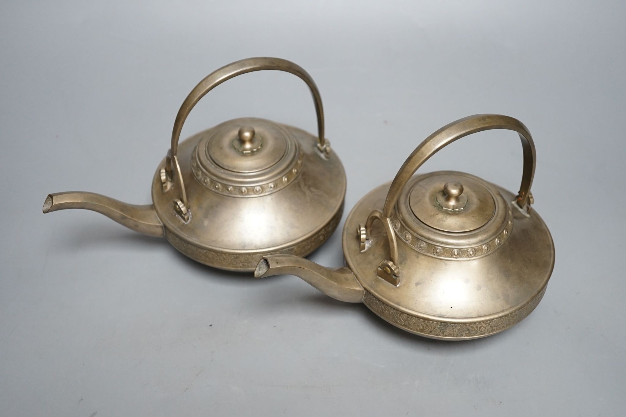 A pair of bronze teapots